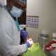 Dentist examining a patient's mouth during a chairside check-up at Dental Quest, Dwarka